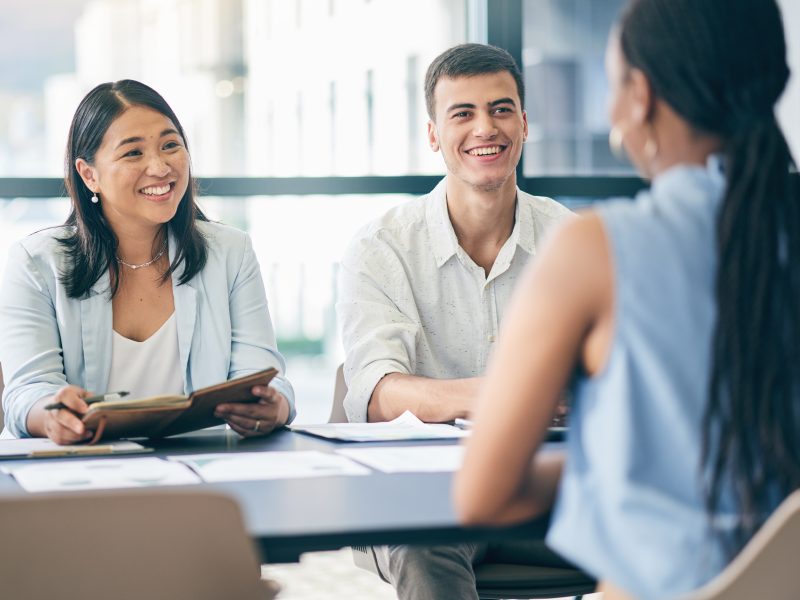 Two HR consultants meeting with a job candidate during a strategic HR consultancy session aimed at organizational success.